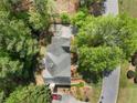 An aerial view of a house with mature trees, a long driveway, and a yard at 535 Woodbrook Way, Lawrenceville, GA 30043