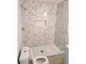 Modern walk-in shower with white marble-patterned tiling and white hexagonal tile floor at 4080 Brushymill Ct, Loganville, GA 30052
