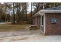 Brick exterior of home with sidewalk to the side and neutral colored siding at 679 Winchester Ln, Norcross, GA 30071