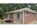 Exterior of a single-story house featuring a brick facade, dark shutters, and neutral-toned siding at 679 Winchester Ln, Norcross, GA 30071