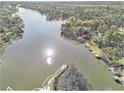 Panoramic aerial view showcases the serene lake and lush greenery surrounding the waterfront property at 2220 Emerald Dr, Jonesboro, GA 30236