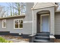 Close-up of a front door with brick archway and gray color scheme, complemented by a small yard at 360 Peyton Sw Rd, Atlanta, GA 30311