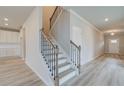 Inviting entryway featuring a staircase with wood and iron railings and luxury vinyl plank flooring at 138 Crabbswood Dr, Mcdonough, GA 30253
