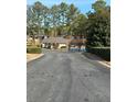 Exterior shot of townhouse complex featuring mature trees, manicured shrubs, and community pool at 2340 Beaver Ruin Rd, Norcross, GA 30071