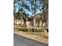 View of multi-story townhouse complex featuring mature trees and well-maintained landscaping at 2340 Beaver Ruin Rd, Norcross, GA 30071