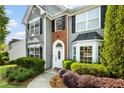 Close-up of home's entrance with brick accents, white door and trim, and mature landscaping at 2360 Brookgreen Commons, Kennesaw, GA 30144
