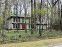 Beautiful home with a red door surrounded by trees, providing a sense of privacy and seclusion at 257 Forest Lake Rd, Lawrenceville, GA 30046
