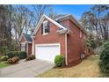 Brick home with a two-car garage, manicured lawn, and mature trees at 4236 Providence Ln, Tucker, GA 30084