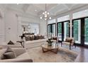 A cozy living area with a fireplace, large windows, and elegant furniture arrangement at 821 Camden Park Ct, Atlanta, GA 30342