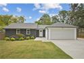 Charming home featuring black brick, a well-manicured lawn, an attached two-car garage, and a welcoming front entrance at 2041 Briarcliff Ne Rd, Atlanta, GA 30329