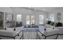 Bright living room with vaulted ceilings, shiplap walls, modern furniture, and double doors leading to the outdoor space at 2041 Briarcliff Ne Rd, Atlanta, GA 30329