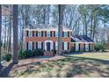 Well-maintained two-story brick home with a symmetrical facade, dark shutters, and a neatly landscaped front yard at 725 Glengary Ne Way, Atlanta, GA 30342