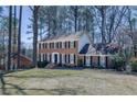 Traditional two-story brick home featuring black shutters and a well-maintained lawn, nestled in a wooded setting at 725 Glengary Ne Way, Atlanta, GA 30342