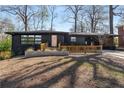 Charming single-story home featuring a black exterior, a wooden porch, and a well-manicured front yard at 2382 Whites Mill Ln, Decatur, GA 30032