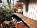 Backyard view featuring a charming wooden bridge over a koi pond with rock features at 1075 Winding Branch Ln, Atlanta, GA 30338
