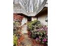 Inviting home entrance featuring a wooden walkway and lush landscaping with flowering bushes at 1075 Winding Branch Ln, Atlanta, GA 30338