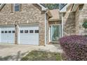 Close-up of home's entrance, two car garage, brick exterior and manicured landscaping at 1312 Birch Ct, Lithonia, GA 30058