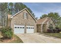 Attractive brick home with attached two-car garage, driveway and manicured landscaping at 1312 Birch Ct, Lithonia, GA 30058