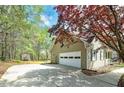 Side angle of a home featuring a large two-car garage and long concrete driveway at 195 Creekside Way, Mcdonough, GA 30252