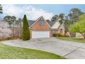 Attractive home with a spacious driveway, lush green lawn, and mature landscaping at 802 Towering Pine Trl, Lawrenceville, GA 30045