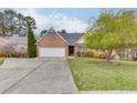 Beautiful brick home with a two-car garage, green lawn, and mature trees at 802 Towering Pine Trl, Lawrenceville, GA 30045