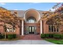 Grand brick home entrance featuring stately columns and an arched doorway at 1483 Jones Rd, Roswell, GA 30075