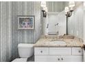 Elegant powder room with granite countertop, modern fixtures, and stylish wallpaper at 2993 Saint Annes Nw Ln, Atlanta, GA 30327