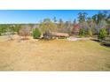 Expansive property showcasing a charming home with a long driveway, mature trees, and a well-manicured lawn at 9095 Cedar Grove Rd, Fairburn, GA 30213