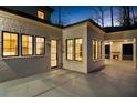 Covered back patio with an outdoor fireplace, fan, and black framed windows that open to the kitchen at 942 Fairfield Dr, Marietta, GA 30068