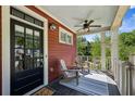 Inviting covered front porch featuring wood flooring, ceiling fan, comfortable chairs, and views of the manicured lawn at 1145 Verandah Se Ln, Atlanta, GA 30316