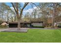 Charming single-story home with lush front lawn, mature trees, and an attached garage at 3473 Regalwoods Dr, Atlanta, GA 30340