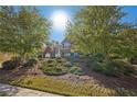 Beautiful two-story home surrounded by mature trees, set on a manicured lawn at 4950 Luke Dr, Cumming, GA 30040