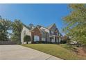 Well-maintained home with a lush green lawn, mature trees, and a private driveway at 4950 Luke Dr, Cumming, GA 30040