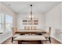 Bright dining room with a modern chandelier, elegant chairs, and a rustic wooden table at 708 Chipping Sparrow St, Canton, GA 30115