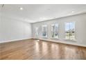 Sun-drenched living room featuring gleaming hardwood floors and multiple windows letting in abundant natural light at 104 Briargate Dr, Johns Creek, GA 30097