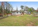 Spacious yard showcasing a charming one-story home with stone accents and a quaint porch at 1752 Atherton Dr, Decatur, GA 30035