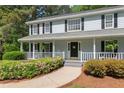 Inviting front porch with chairs, hanging ferns, and a beautifully landscaped walkway at 2731 Old Coach Rd, Duluth, GA 30096