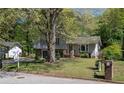Split-level home with stone accents, a well-maintained lawn, and mature trees at 8876 Ashwood Dr, Riverdale, GA 30274