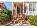 Brick front entrance featuring a stairway with black railings leading to an open door at 5210 Davenport Pl, Roswell, GA 30075