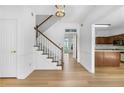 Bright foyer featuring hardwood floors, a staircase with white railing, and views into the kitchen at 165 River Ridge Ln, Roswell, GA 30075