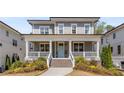 Charming two-story home featuring a welcoming front porch, beautiful gray siding and manicured landscaping at 2033 Lee Se Rd, Smyrna, GA 30080