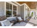 Inviting front porch with comfortable wicker chairs, pillows and a wooden ceiling at 2033 Lee Se Rd, Smyrna, GA 30080