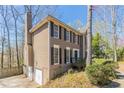 Side view of a two-story home with a brick chimney, a two-car garage, and a landscaped yard at 2072 Arbor Forest Sw Dr, Marietta, GA 30064