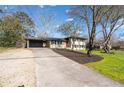 View of the two-story home with a long driveway, landscaped yard, and mature trees under a clear sky at 399 W Sandtown Sw Rd, Marietta, GA 30064