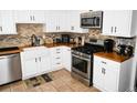 Well-equipped kitchen with stainless steel appliances, white cabinetry, and stylish backsplash at 811 Heritage Valley Rd, Norcross, GA 30093