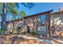 Beautiful two-story brick townhouse featuring dark shutters, mature landscaping, and a cozy front entrance at 748 Garden View Dr, Stone Mountain, GA 30083