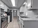 Modern kitchen features stainless appliances, white cabinets, marble countertops, and sleek tile flooring at 748 Garden View Dr, Stone Mountain, GA 30083
