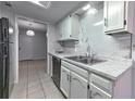 The kitchen has white cabinetry, marble countertops and backsplash, and stainless steel appliances at 748 Garden View Dr, Stone Mountain, GA 30083