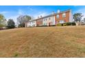 Exterior view of townhomes featuring a grassy lawn and blue sky at 219 Holcomb Ferry Rd, Roswell, GA 30076
