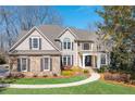 Charming home featuring stone accents, gray siding, manicured lawn, and beautiful landscaping at 5303 Whitehaven Park Se Ln, Smyrna, GA 30126